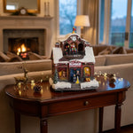 Decoratiune Muzicala de Craciun cu Luminare LED, model Santa Workshop cu Mos Craciun in mansarda, ceas decorativ, acoperis inzapezit, ferestre cu jucarii, copii la intrare