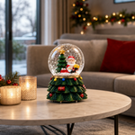 Glob de Zăpadă Premium de Crăciun cu Moș Crăciun, Bază tip Brad Decorat, Muzică, Lumină LED și Efect de Ninsoare – 15 × 10 cm