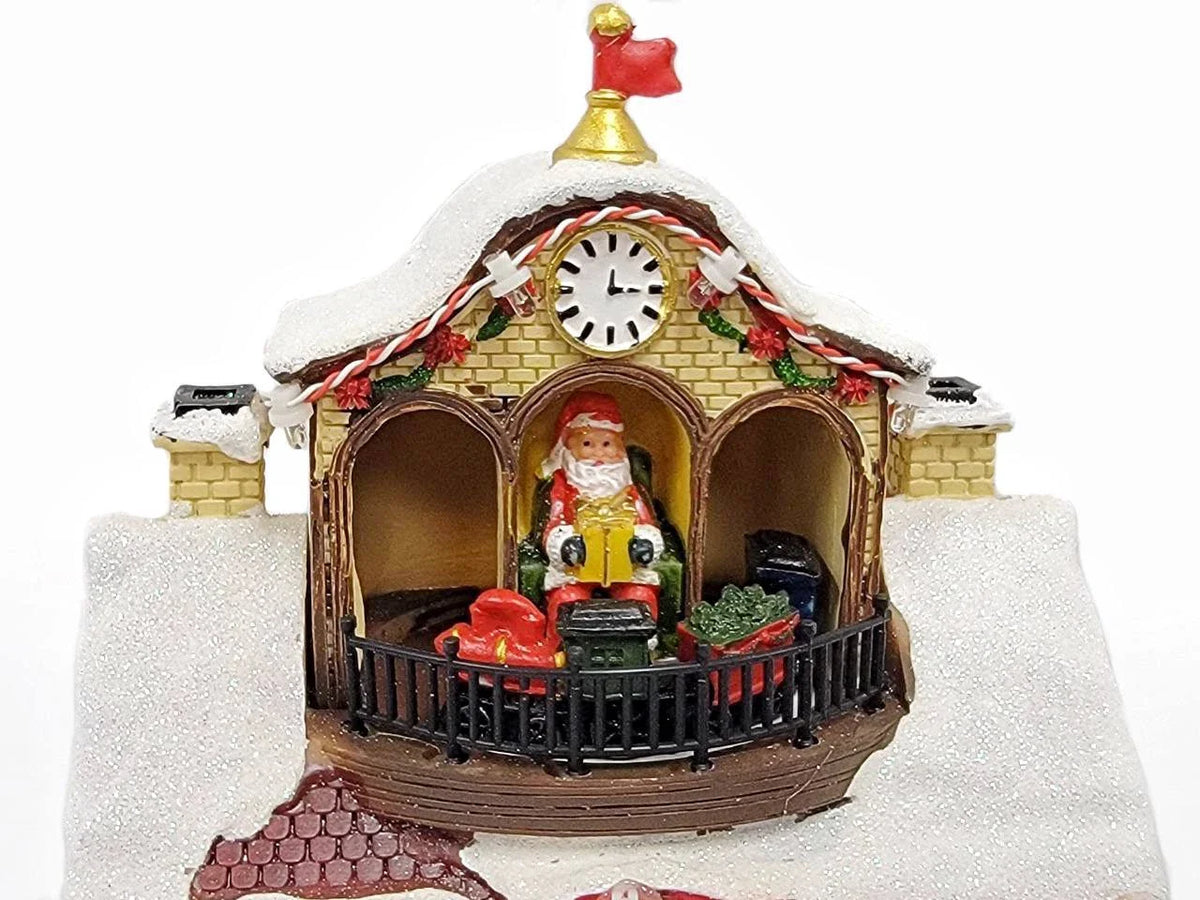 Decoratiune Muzicala de Craciun cu Luminare LED, model Santa Workshop cu Mos Craciun in mansarda, ceas decorativ, acoperis inzapezit, ferestre cu jucarii, copii la intrare